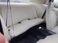 A 1974 Dodge Challenger with white leather seat upholstery in the rear seat area featuring vertical stitching and seatbelts