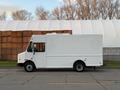 A white 2017 Freightliner M Line delivery truck with a rectangular body and large side windows parked on a street