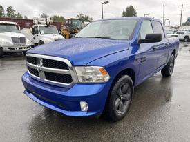 A blue 2019 RAM 1500 Classic with a chrome grille and black accents parked in a wet environment