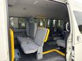 Interior of a 2009 Toyota Hiace showing multiple seats in a light gray color with yellow accents and a spacious layout designed for passengers