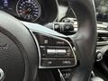 Close-up of the steering wheel of a 2021 Kia Forte featuring buttons for cruise control and audio settings