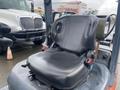 A 2011 Toyota 028FG15 forklift seat with a worn cushion and visible damage on the left side