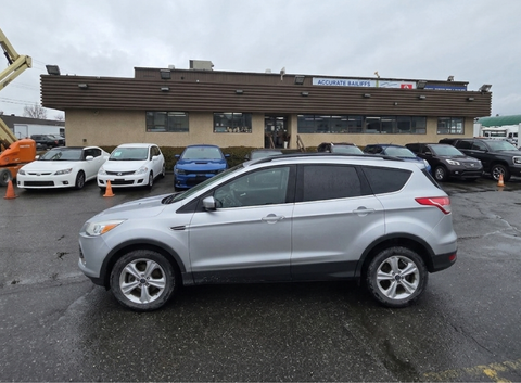 A 2015 Ford Escape in silver color parked with its side facing the viewer showcasing its design features and wheels
