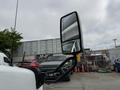 A 2020 Chevrolet Express with a large side mirror prominently displayed in the foreground