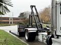 A 2020 Peterbilt 330 truck with a flatbed and hydraulic lift system is positioned for loading or unloading cargo