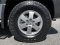 A close-up of a silver alloy wheel of a 2017 Mercedes-Benz Sprinter with a rugged tire showcasing its tread pattern