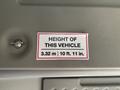 A sign indicating the height of a 2017 Chevrolet Express vehicle stating 3.32 m and 10 ft 11 in