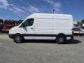 A 2010 Mercedes-Benz Sprinter van in white with a high roof and black accents, featuring alloy wheels and a side view showcasing its spacious design