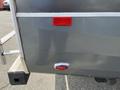 A rear view of a 2013 Outdoor Wind River with a red reflector and a chrome accent near the bottom of the vehicle