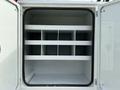 An open compartment of a 2008 International 4300 with multiple white shelves divided into sections for storage