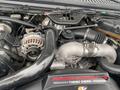 Close-up view of a 2003 Ford F-450 SD engine featuring a Power Stroke V8 Turbo Diesel with visible components like the alternator and turbocharger