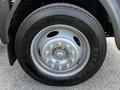 A close-up of a silver wheel and tire of a 2009 Ford LCF 550 showing the rim design and Firestone tire with visible tread pattern