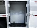An empty storage compartment of a 2012 Freightliner M2 106 truck with open doors and a gray interior
