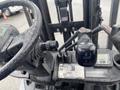 Close-up of a 2011 Toyota 028FG15 forklift control panel showing the steering wheel throttle lever and hydraulic controls