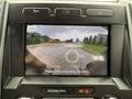 2022 Ford F600 dashboard display showing a rearview camera perspective of a road with a message to check surroundings for safety