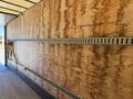 Interior of a 2015 Freightliner M2 106 truck trailer showing wooden walls with metal tracks and a strap secured to the side