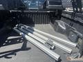 A 2010 Toyota Tacoma truck bed with multiple aluminum cargo bars arranged neatly on the floor