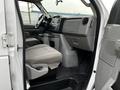 Interior view of a 2011 Ford Econoline showing the driver's seat dashboard and center console with cup holders