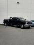 2015 Chevrolet Silverado 3500HD in black with a crew cab and large wheels parked in a lot