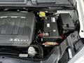 Engine compartment of a 2011 Dodge Grand Caravan featuring a 3.6L VVT engine and battery with various components and wiring visible