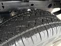 Close-up of a rugged tire on a 2015 GMC Sierra 1500 showcasing deep tread patterns and water droplets on its surface