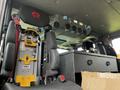 Interior view of a 2009 Spartan Gladiator featuring black seats with red logos and a console area with storage compartments and mounted equipment