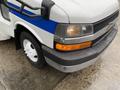 Front view of a 2015 Chevrolet Express with a gray and blue exterior showcasing lights and a black bumper with a single white wheel visible