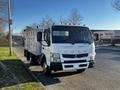 A 2014 Mitsubishi Fuso FE truck with a flatbed and multiple side compartments, featuring orange signal lights on the roof and a white exterior