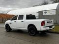 A white 2022 RAM 1500 Classic pickup truck parked with a crew cab and black rims showcasing its bold design and spacious bed