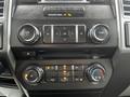 The interior controls of a 2017 Ford F-150 including knobs for volume climate control and various buttons for audio and settings