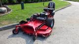 A red 2014 Ferris Mower ISX 800 featuring a seat and large cutting deck with several blades and rear wheels designed for commercial lawn care