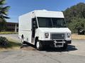 A white 2019 Freightliner MT45 box truck with a flat front and large windshield parked to the side with an empty cargo area and a front bumper guard