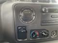 A close-up view of the dashboard controls of a 2010 Ford Econoline featuring air conditioning and fan speed dials along with radio and volume controls