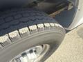 A 2007 Chevrolet Express van with a focus on the front tire showing significant tread patterns
