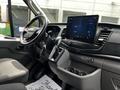 Interior view of a 2022 Ford Transit showcasing the dashboard with a touchscreen display and gear shift along with steering wheel and controls
