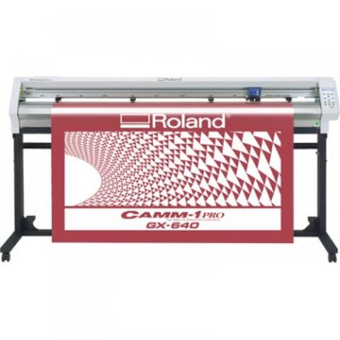 A Roland CAMM-1 GX-640 cutting plotter with a red and white geometric design displayed on its vinyl roll. The machine features a control panel on the right side.