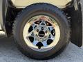 Close-up of a shiny chrome wheel and tire on a 2016 GMC Sierra 1500 showcasing the tread and rim design