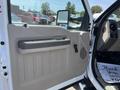 Interior door panel of a 2008 Ford F-450 SD featuring a gray handle and speaker grille with storage space below the handle