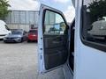 A 2020 Chevrolet Express van with its driver door open showing the interior door handle and mirror