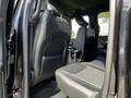Interior view of the back seats of a 2019 RAM 1500 featuring black leather and fabric upholstery with cup holders in the center console