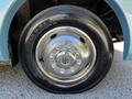 Close-up of a shiny wheel and tire from a 2000 Ford Motorhome featuring a five-lug bolt pattern and a black tire with raised lettering