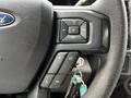 Close-up of a Ford steering wheel featuring audio control buttons and phone command options