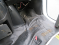Interior floor of a 2020 Chevrolet Express with visible wear and tear including scuff marks and an exposed area where parts are missing