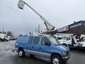 A blue 2006 Ford Econoline van with an elevated bucket lift attached on the roof