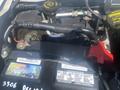 Close-up of the battery and engine components of a 2009 Ford Econoline showing labels and connections