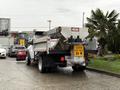 A 2012 Dodge Ram 5500 dump truck with a raised bed and caution sign on the back parked in a gravel area