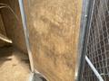 2020 Stealth Enterprises Trailer with a weathered plywood wall and metal frame features evident wear and usage marks