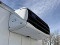 A Carrier rooftop air conditioning unit mounted on a large vehicle with a sleek white design and black grilles