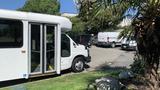 A 2011 Chevrolet Express van with a white exterior parked in a lot with a sliding door open showing interior seating