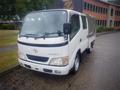 A white 2003 Toyota Toyoace truck with a covered cargo bed and a large windshield showcasing the front grille and headlights